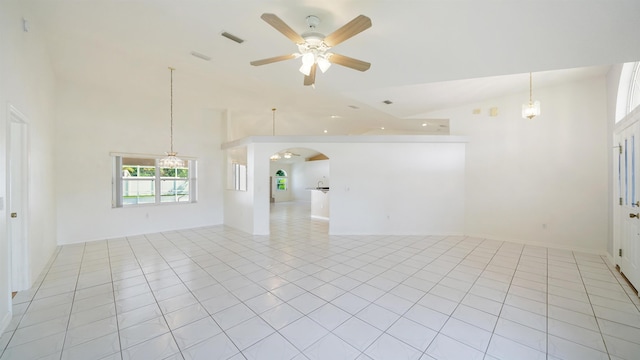 53 Pritchard Dr, Palm Coast, FL 32164 - spare room with high vaulted ceiling, arched walkways, ceiling fan, light tile patterned floors, and a chandelier