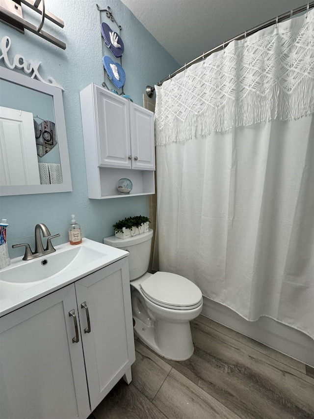 bathroom with hardwood / wood-style floors, vanity, toilet, a textured ceiling, and a shower with curtain