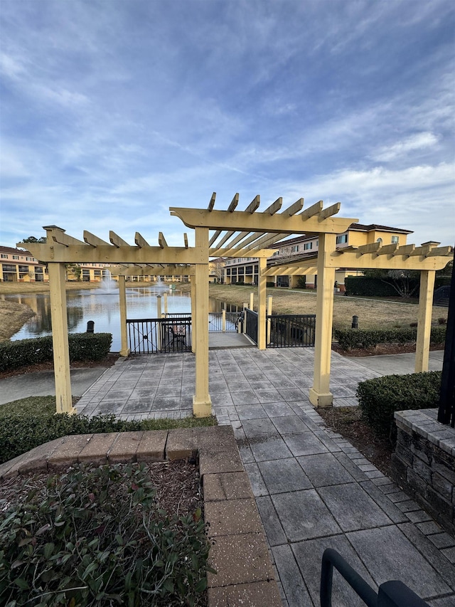 view of patio with a water view and a pergola