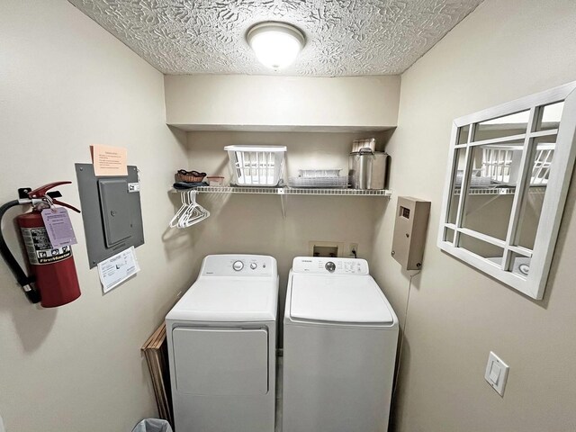 washroom with laundry area, separate washer and dryer, and a textured ceiling