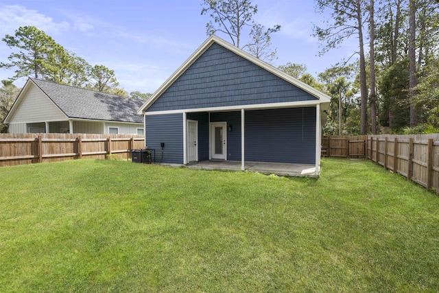 back of property featuring a fenced backyard, a lawn, and a patio