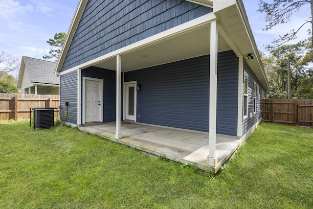 exterior space featuring a yard, a patio area, fence, and central AC unit