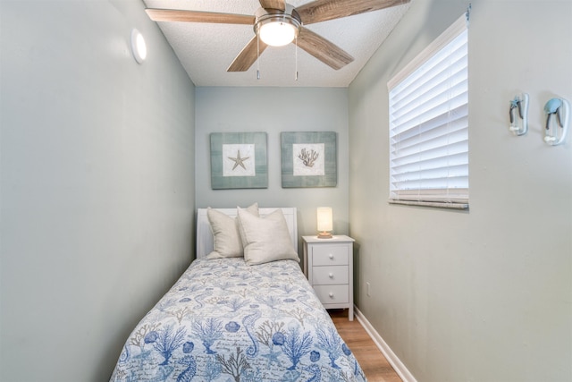 bedroom featuring ceiling fan, a textured ceiling, and hardwood / wood-style flooring