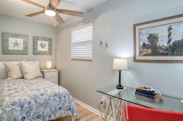 bedroom with a textured ceiling, light wood-type flooring, and ceiling fan