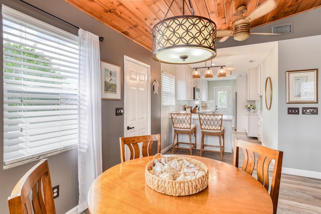 dining area with light wood-type flooring, ceiling fan, and wood ceiling