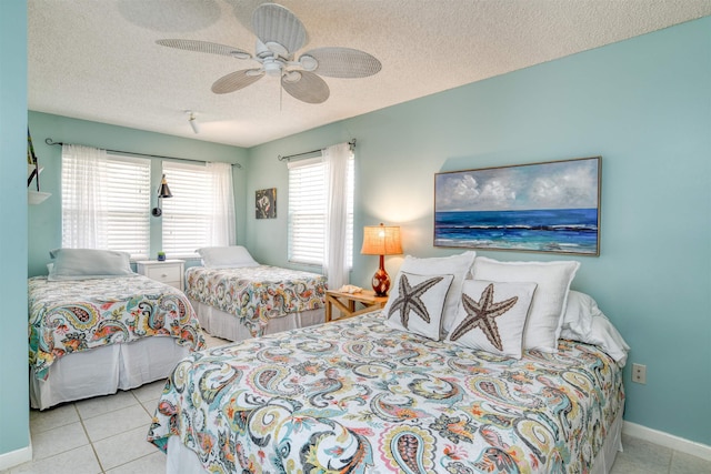 tiled bedroom with ceiling fan and a textured ceiling