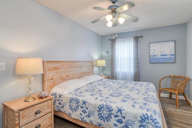 bedroom featuring a textured ceiling, ceiling fan, and dark wood-type flooring