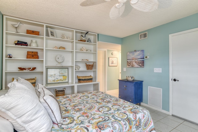 tiled bedroom with ceiling fan and a textured ceiling