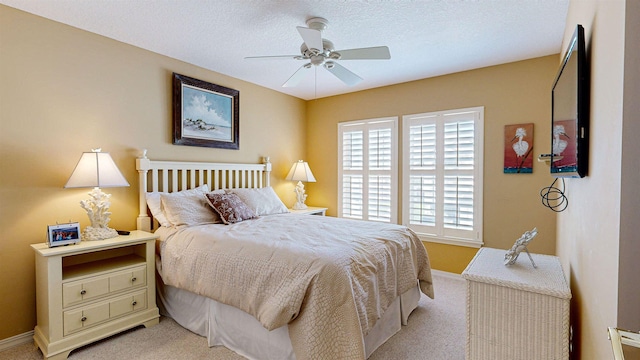 bedroom featuring light colored carpet, ceiling fan, and a textured ceiling