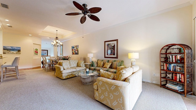 living room with ceiling fan with notable chandelier, a raised ceiling, and light colored carpet