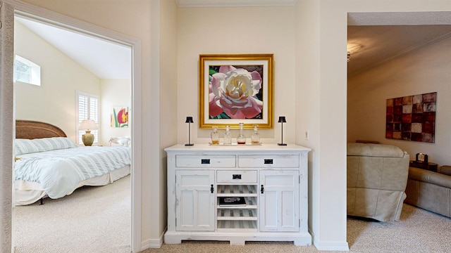 bar with ornamental molding, light colored carpet, white cabinetry, and vaulted ceiling