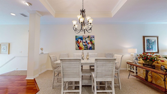 dining area with ornamental molding, an inviting chandelier, and a tray ceiling