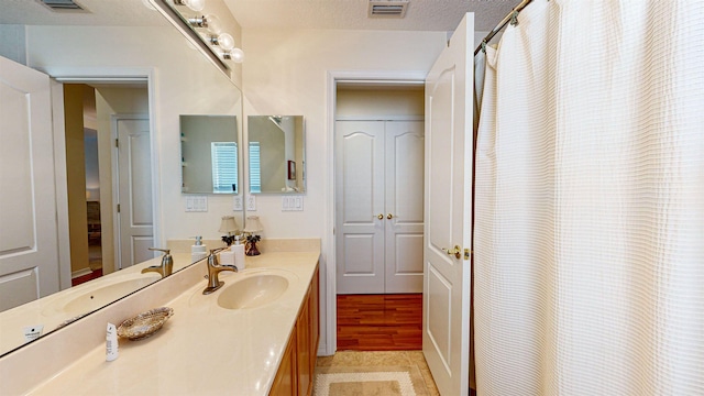 bathroom featuring a textured ceiling and vanity