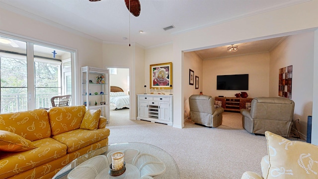 living room with ceiling fan, ornamental molding, and carpet