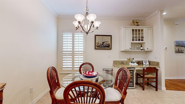 tiled dining area featuring an inviting chandelier, ornamental molding, and wine cooler