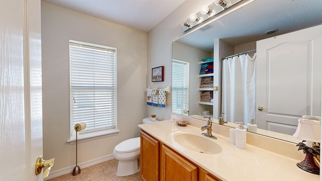 bathroom with toilet, vanity, tile patterned floors, and plenty of natural light