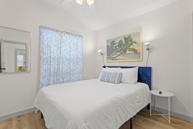 bedroom with baseboards, vaulted ceiling, a ceiling fan, and wood finished floors