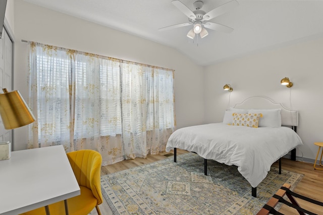 bedroom with ceiling fan, lofted ceiling, and wood finished floors