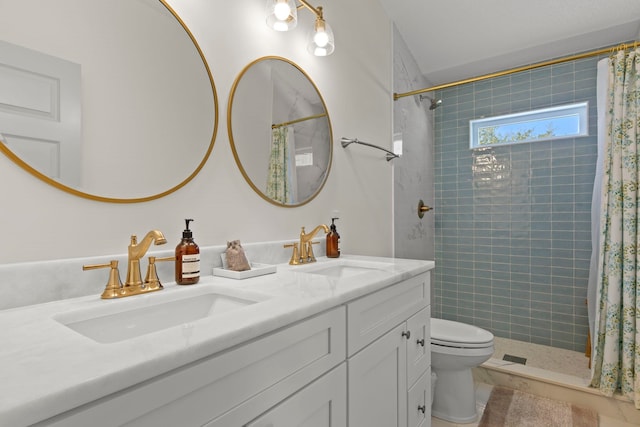 bathroom featuring toilet, tiled shower, and a sink