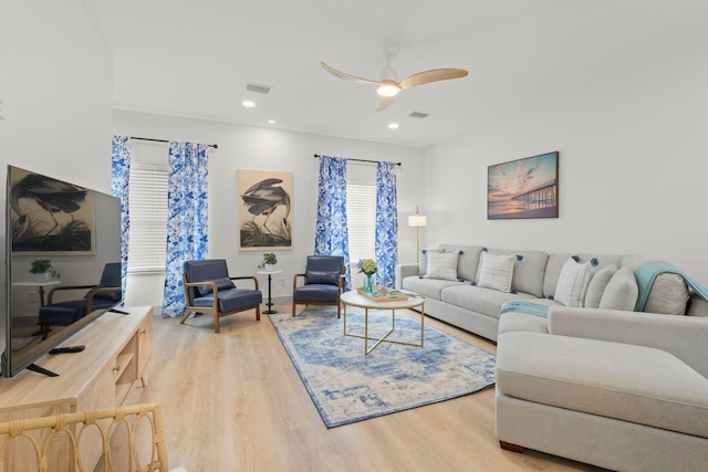 living room featuring visible vents, wood finished floors, and ceiling fan