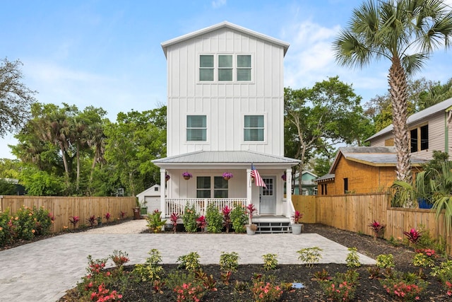 view of front of home featuring board and batten siding, a porch, and fence private yard