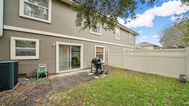 rear view of house with a yard and central AC unit