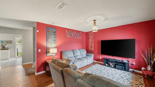 living room with hardwood / wood-style floors and a textured ceiling