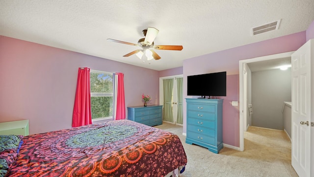 carpeted bedroom with ceiling fan and a textured ceiling