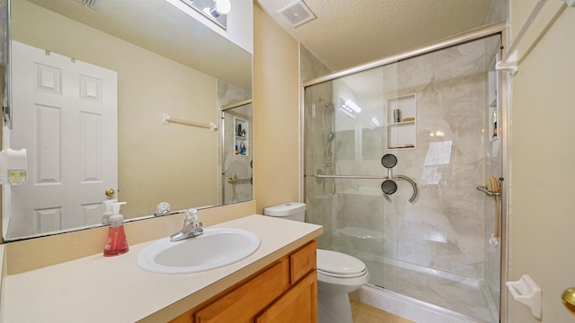 bathroom with vanity, toilet, an enclosed shower, and a textured ceiling