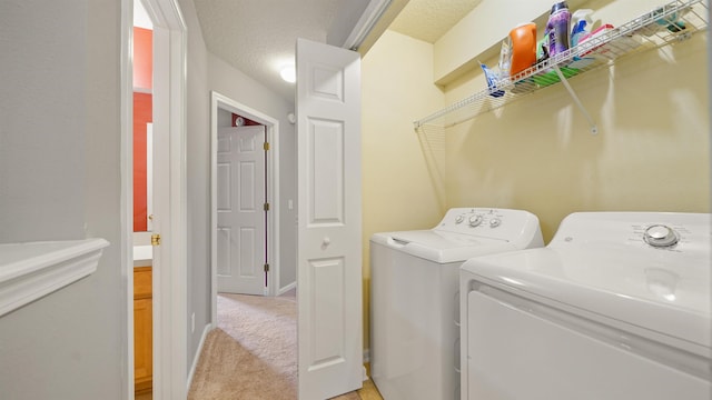 washroom with separate washer and dryer, light carpet, and a textured ceiling