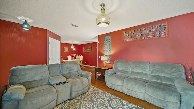 living room with wood-type flooring and a textured ceiling