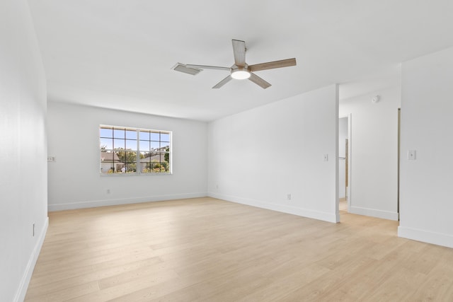 unfurnished room with a ceiling fan, light wood-type flooring, visible vents, and baseboards