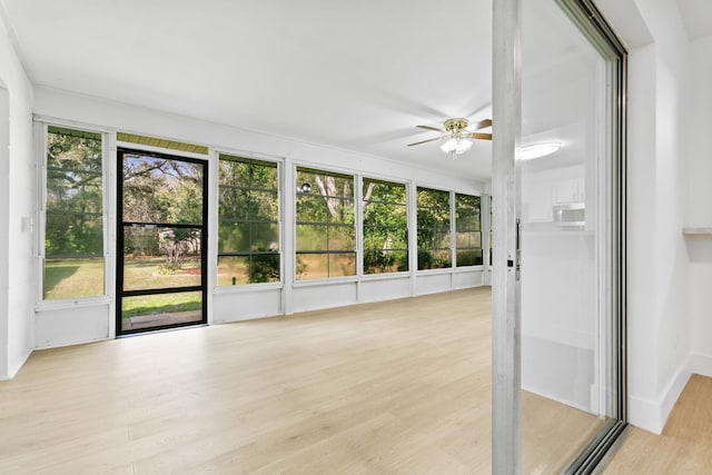 unfurnished sunroom with a healthy amount of sunlight and ceiling fan