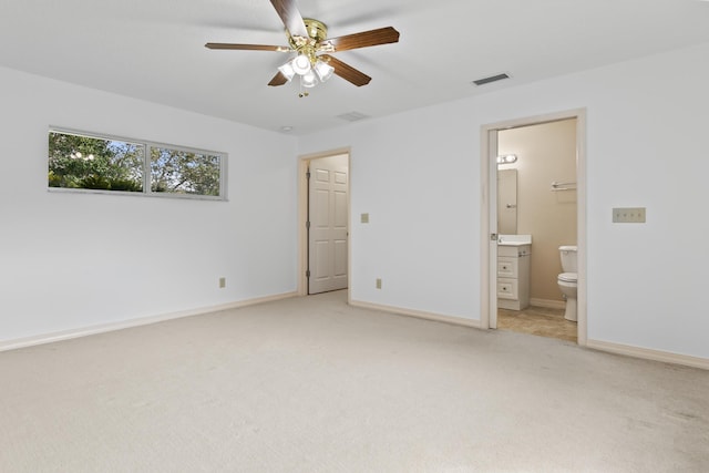 unfurnished bedroom featuring baseboards, visible vents, connected bathroom, and light colored carpet