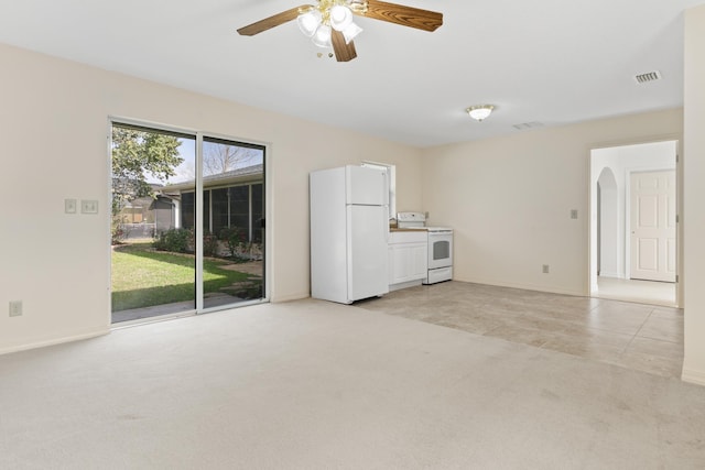 unfurnished living room with light carpet, visible vents, arched walkways, and a ceiling fan