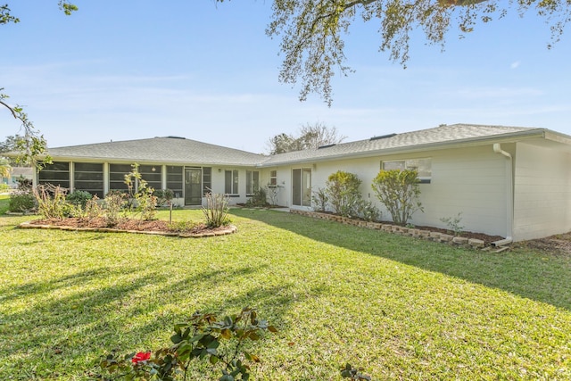 rear view of property with a sunroom and a yard