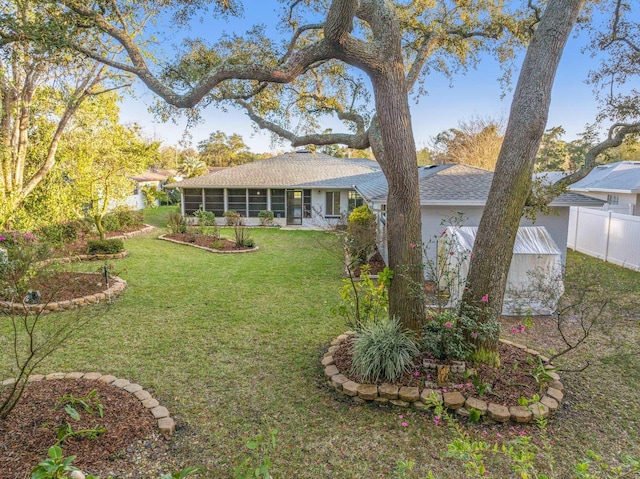 view of yard featuring fence and a sunroom