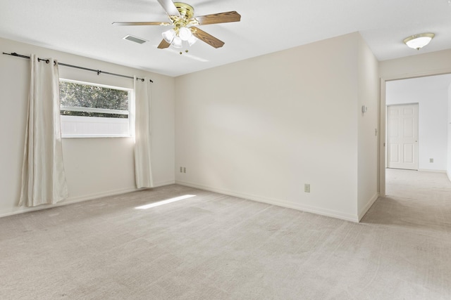 empty room with carpet floors, visible vents, baseboards, and a ceiling fan