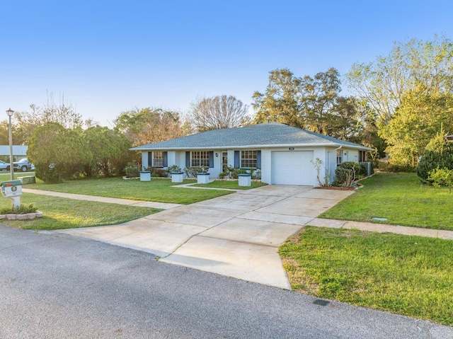 ranch-style home with a front yard, concrete driveway, and an attached garage