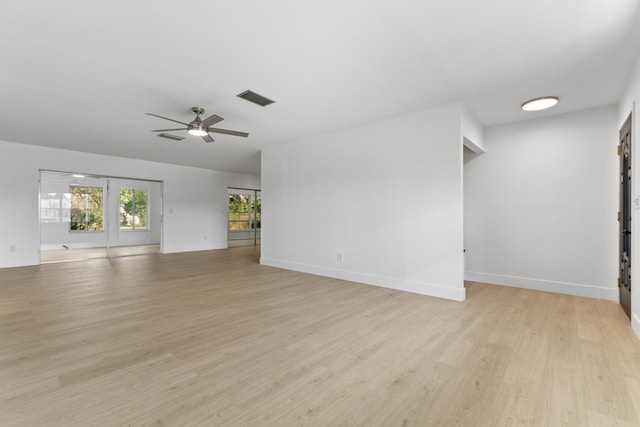 unfurnished living room featuring baseboards, visible vents, ceiling fan, and light wood finished floors