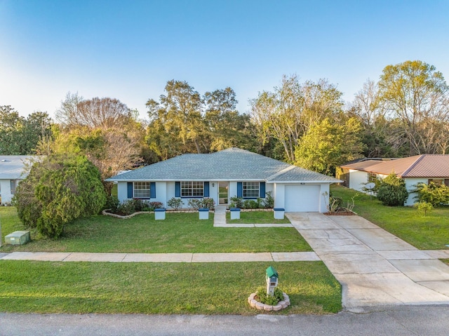 single story home with driveway, a front lawn, and an attached garage