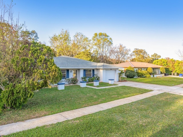 single story home featuring a garage, a front lawn, and concrete driveway