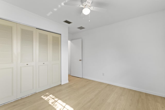 unfurnished bedroom with baseboards, a closet, visible vents, and wood finished floors