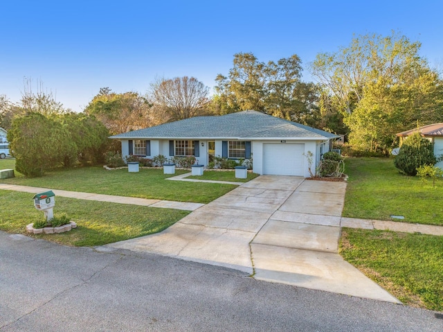 single story home featuring an attached garage, driveway, and a front lawn