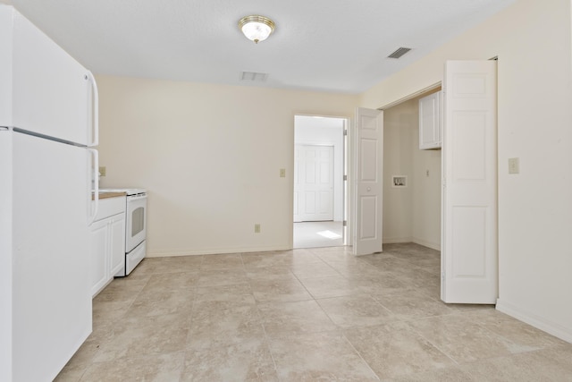 kitchen with white appliances, visible vents, baseboards, and white cabinets