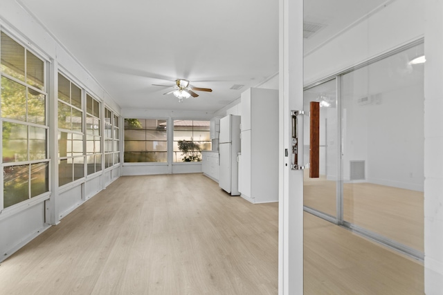 unfurnished sunroom featuring ceiling fan and visible vents