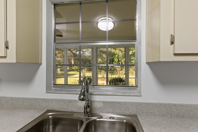 kitchen featuring light countertops, white cabinets, and a sink