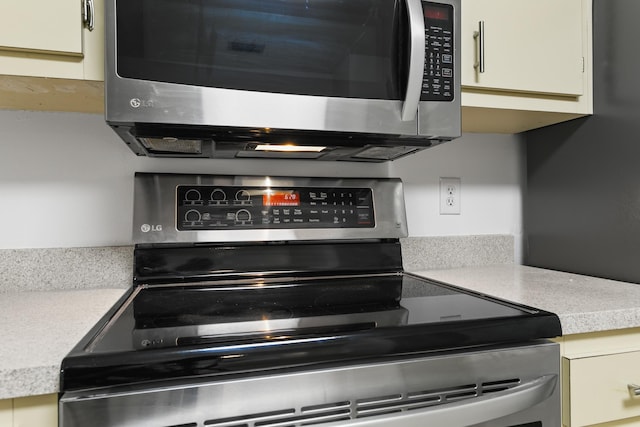 kitchen featuring stainless steel appliances, white cabinets, and light countertops