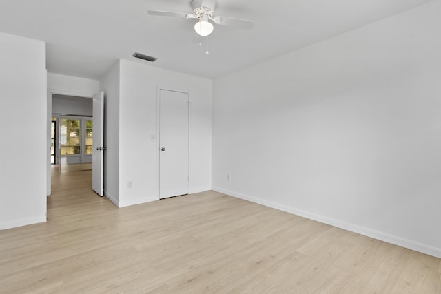 unfurnished bedroom featuring ceiling fan, light wood-type flooring, visible vents, and baseboards