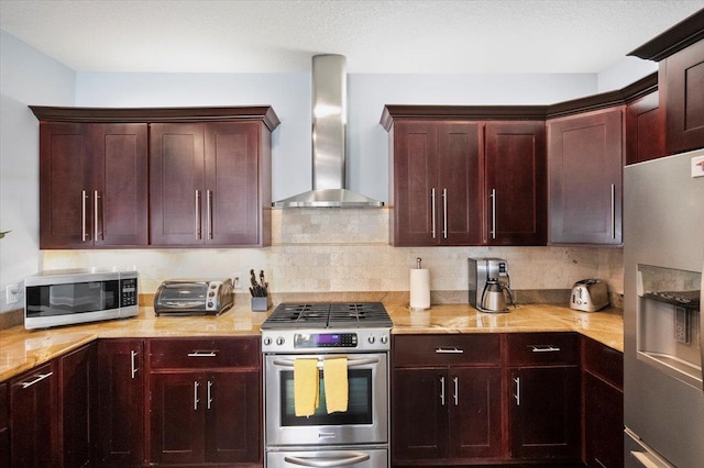 kitchen featuring stainless steel appliances, tasteful backsplash, and wall chimney range hood